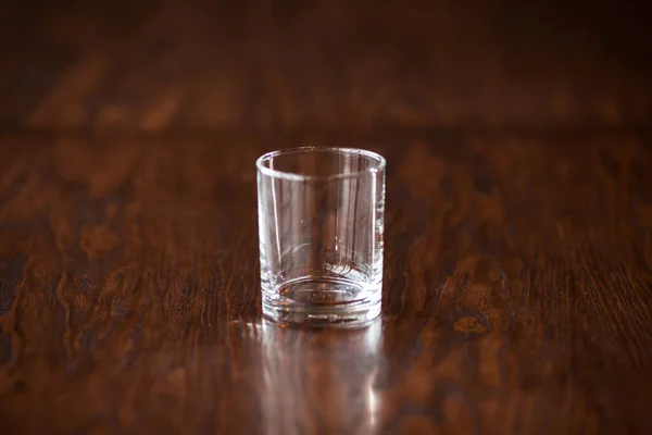 Prázdné elegantní čisté sklo na tmavém dřevěném stole — Stock fotografie