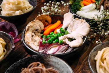 İçinde Asya mutfağı mantarlı bezelye bebek havucu var.