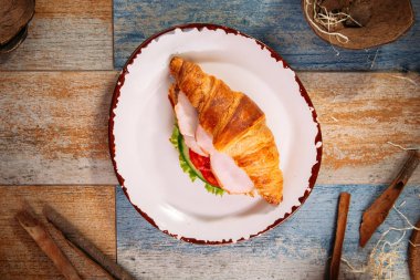 Jambonlu ve sebzeli kruvasan sandviç.