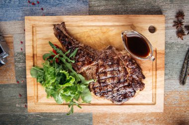 Sosu ve yeşilliği olan lezzetli bir biftek.