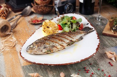 Salata ve limonlu ızgara alabalık.