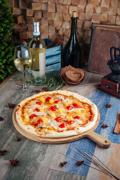 Chicken and pineapple pizza with cherry tomatoes