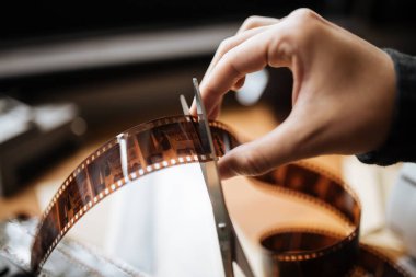Bir adam 35 mm 'lik bir film kesiyor. Klasik, hippi, yaşlı