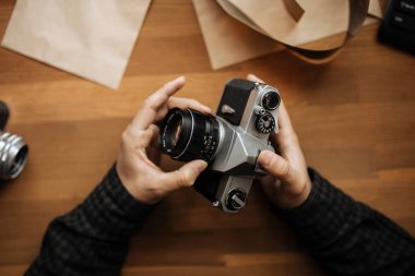 Erkek eli beyaz bir masa üzerinde mercek pentax retro kamera ayarlar