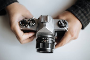Klasik Pentax film kamerası beyaz arka plandaki bir adamın elinde.