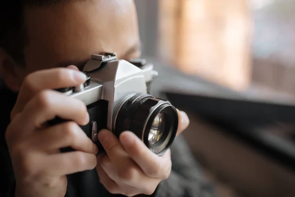 Hombre tomando una foto en una cámara de película pentax contra una ventana — Foto de Stock