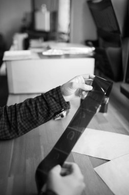 Adam orta formatta bir filmi inceliyor. Eski model. Dikey