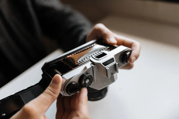 Male hands reloading film retro camera on a white table — Stock Photo, Image