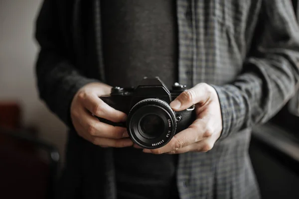 Hombre en camisa oscura hombre manos sostiene cámara retro — Foto de Stock