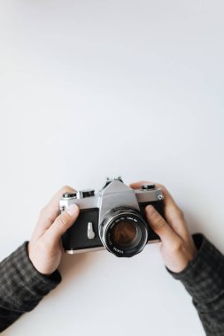 Beyaz arka plandaki adamın elindeki klasik film kamerası.