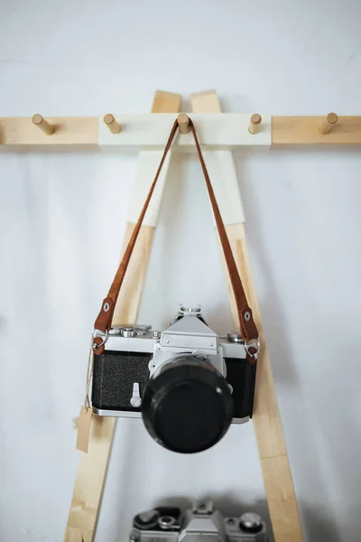 Ретро-камера, висящая на ремешке на белом фоне — стоковое фото
