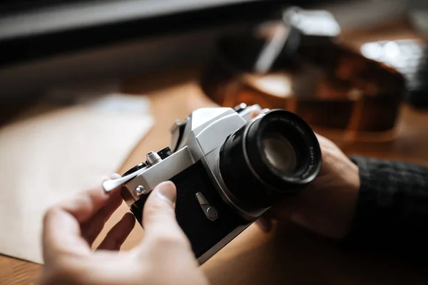 Hombre manos ajusta la cámara retro lente en una mesa de madera — Foto de Stock