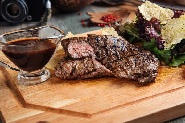 Paardenvlees biefstuk met saus op de houten plank — Stockfoto