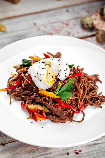 Buckwheat soba noodles wok beef and poached egg — Stock Photo, Image