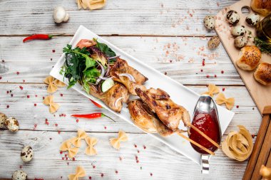 Salata ve kırmızı soslu bıldırcın ızgara şiş.