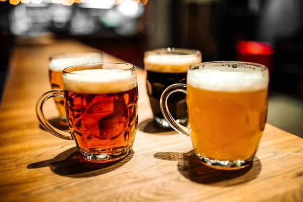 Mugs of different craft beer at the bar blurry — Stock Photo, Image