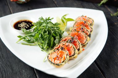 Deep-fried salmon rolls with arugula and soy sauce