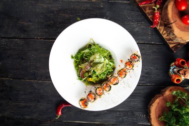 Deep-fried salmon rolls with arugula and soy sauce