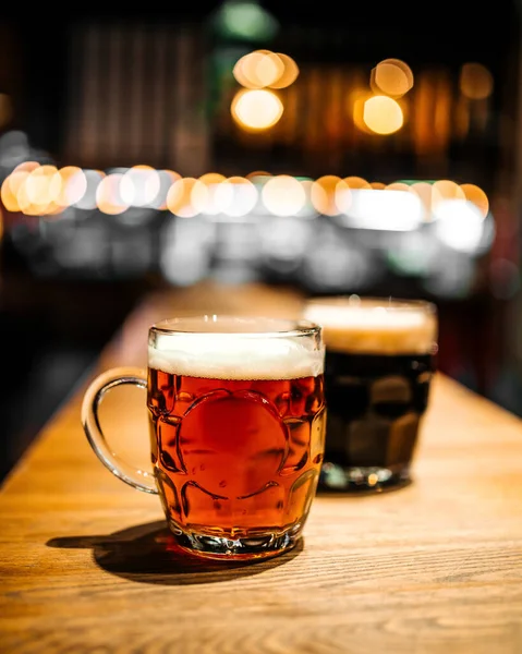 Mugs of craft beer at bar with blurry background — Stock Photo, Image