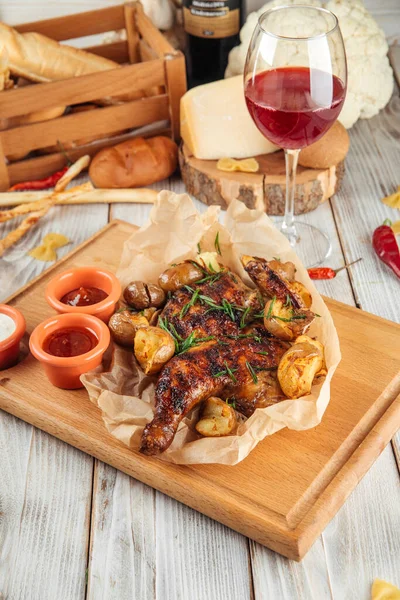 Tobacco chicken with young potatoes  wooden board — Stock Photo, Image