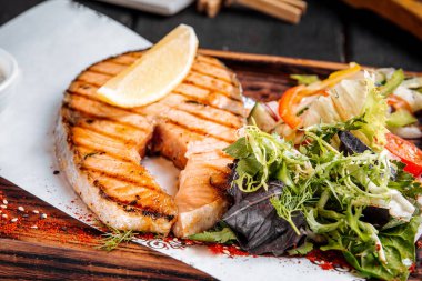 Yeşil salata ve limonlu ızgara somon bifteği.