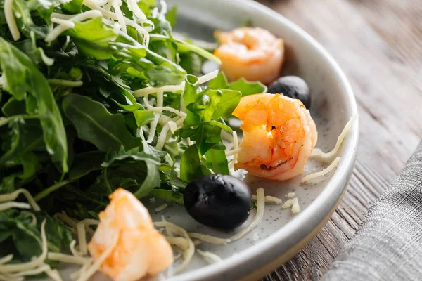 Fresh arugula salad with shrimps and olives — Stock Photo, Image