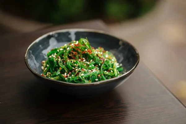 Зелений салат з морських водоростей чука в чорній мисці — стокове фото