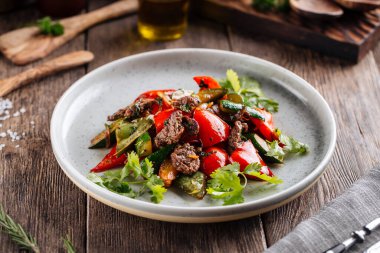 Tabakta biftek ve sebzeli sıcak salata.