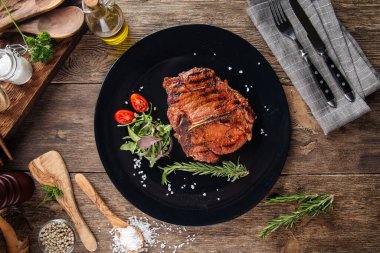 Siyah bir tabakta sulu bifteğin üst görüntüsü