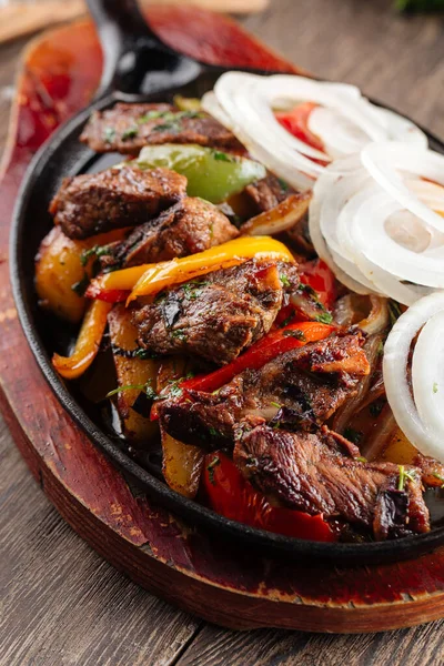 Gebackenes Rindfleisch mit Gemüse in gusseiserner Pfanne — Stockfoto