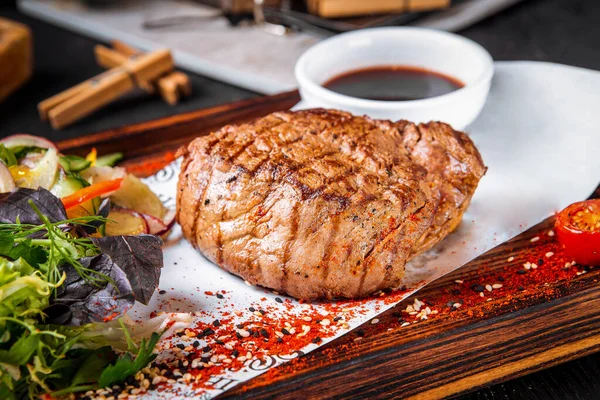 Fillet mignon steak aan boord met salade en saus — Stockfoto