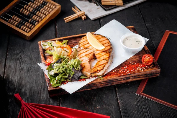 Bife de salmão grelhado com salada e molho branco — Fotografia de Stock