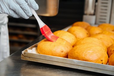 Yumurta sarısı ve mutfak fırçasıyla haşlanmış çörekler.