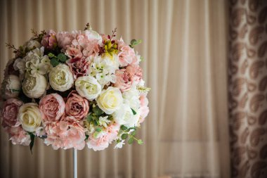 Şölen masasında pembe bir buket çiçek.