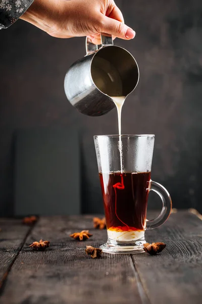 Verser du lait condensé dans une tasse en verre avec du café — Photo