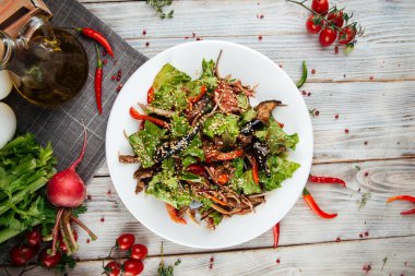Tahta masada biftek sebzeli sıcak salata.
