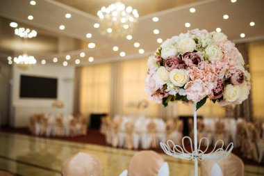 Şölen masasında pembe bir buket çiçek.