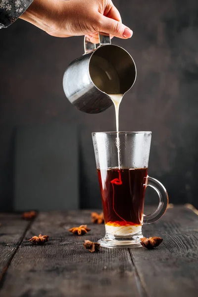 Verser du lait condensé dans une tasse en verre avec du café — Photo