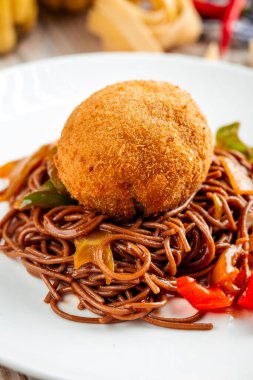 Kızarmış kiev pirzolası ve beyaz tabakta soba eriştesi.