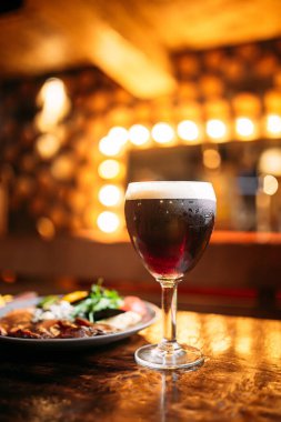 Et ve sebze tabağı ve bir bardak koyu bira.