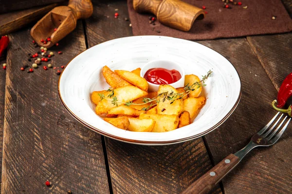 Patates parçaları kekik ve ketçapla süslenir.