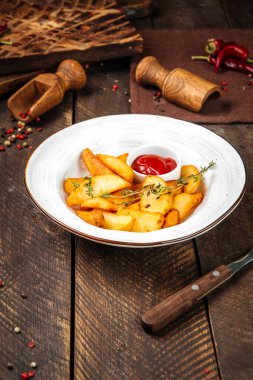 Patates parçaları kekik ve ketçapla süslenir.