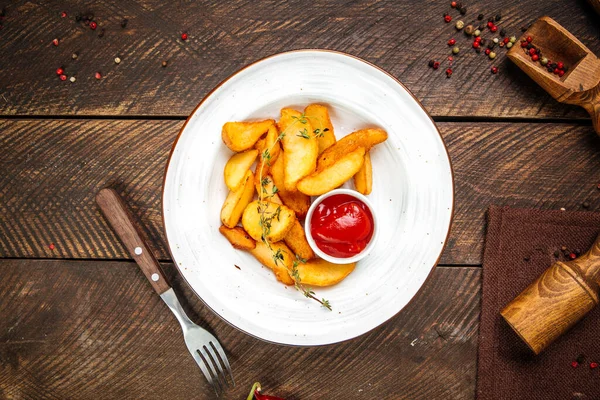 Patates parçaları kekik ve ketçapla süslenir. — Stok fotoğraf