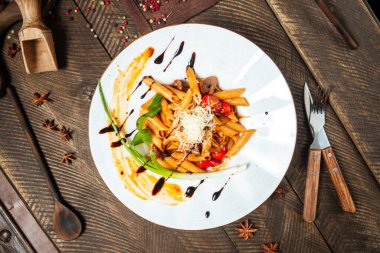 Beyaz tabakta yeşil soğanlı Penne arrabiata