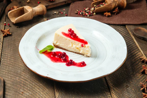 Beyaz tabakta çilek soslu cheesecake.