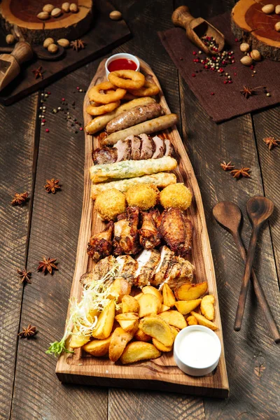 Fried beer snacks on the wooden board with sauces — Stock Photo, Image