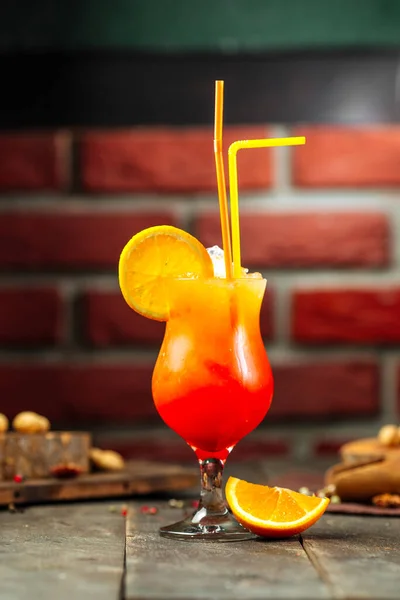 Side view on sunrise fruit cocktail with brick wall — Stock Photo, Image