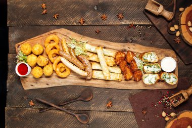 Tahtada soslu kızarmış bira atıştırmalıkları.