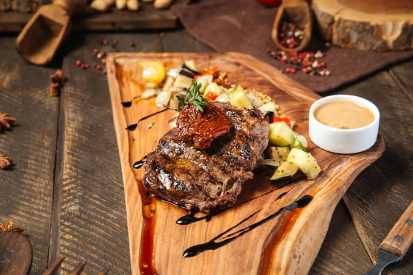 Rundsteak met groenten op het houten bord — Stockfoto