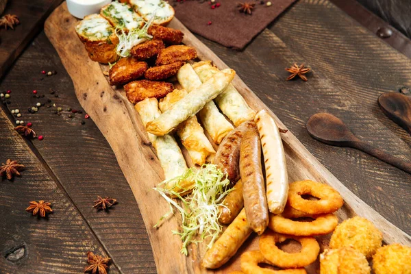 Tahtada soslu kızarmış bira atıştırmalıkları.